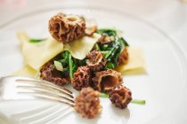 Pasta con spinaci e funghi spugnola (primo piano) — Foto stock