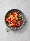 Penne with tomato sauce, rocket and green pepper — Stock Photo