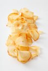 Сушеные желтые картофельные чипсы на белом фоне — стоковое фото