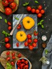 Frische Tomaten, Kirsche, Tomate, Basilikum, Paprika, grün, schwarz, rot, dunkler Hintergrund — Stockfoto