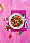 Calabacines con verduras asadas, cebollas, tomate, espárragos, ajo y rematado con micro hierbas y copos de chile - foto de stock