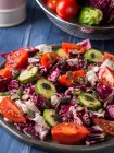 Raw salad with red chicory, cherry tomatoes, zucchini and pumpkin seeds garnished with olive oil and black pepper — Stock Photo