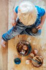 Niño ayudando con la cocina. Ingredientes huevos, cáscaras de huevo y flor. - foto de stock