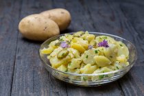 Potato salad with herbs and chive flowers — Stock Photo