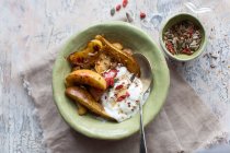 Baked apple and pear slices served with yoghurt, goji and seeds — Stock Photo
