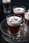 Glasses of coffee schnapps with cream on a tray — Stock Photo