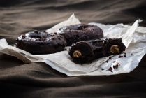 Веганские пончики с начинкой из арахисового масла и темной шоколадной глазурью — стоковое фото