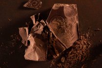 Primo piano di delizioso blocco di cioccolato fondente con trucioli dall'alto — Foto stock