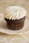Un cupcake au chocolat garni de crème — Photo de stock