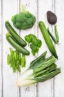 An arrangement of green fruit and vegetables: broccoli, avocado, mange tout, chard, courgette, baby spinach and green chilli peppers — Stock Photo