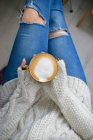 Uma mulher segurando uma xícara de café em suas mãos — Fotografia de Stock