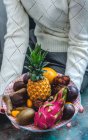 Frutta esotiche su un piatto in mani — Foto stock