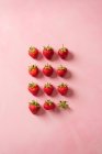 Quatre rangées de fraises, avec deux mangées — Photo de stock