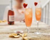Champagne cocktails with hibiscus and strawberry hearts — Stock Photo