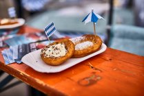 Donuts bávaros com açúcar em pó, creme e pepitas de chocolate em uma mesa de madeira — Fotografia de Stock