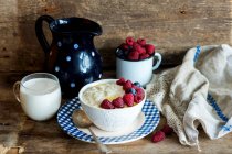 Porridge with fresh berries, berries in mug and glass of milk — Stock Photo