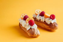 Eclairs with vanilla cream and with berries — Stock Photo
