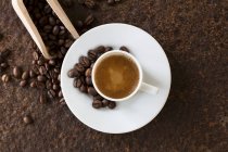 Una tazza di caffè con chicchi di caffè su un piatto di metallo arrugginito — Foto stock
