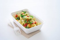 Tortellini con verduras en una caja para llevar - foto de stock