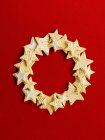Wreath made of stars cookies on red background — Stock Photo