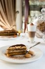 Пирог из тирамису с тушью из мусса, увенчанный кофе и какао порошком и подаваемый с миндальным бискотти — стоковое фото