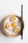 Steamed Chinese dumplings with prawns and fish roe in bamboo steaming basket with chopsticks — Stock Photo