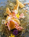 Pasta di lievito dolce Coniglietti pasquali su fieno con fiori primaverili — Foto stock
