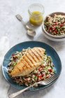 Rice salad with roasted pepper, chilli, dill, parley and lemon dressing and grilled chicken breast — Stock Photo