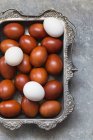 White and brown eggs in vintage silver tray — Stock Photo