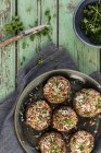 Cogumelos Portobello recheados com parmesão, pinhões, alho, farinha de rosca e salsa em mesa de madeira verde — Fotografia de Stock