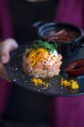 Bistecca di salmone con peperoncini schiacciati, crema fraiche, scorza d'arancia, germogli e salsa di prugne — Foto stock