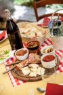 Piatto in legno con antipasti (salsiccia, formaggio, olive, funghi sott'olio e pomodori secchi)) — Foto stock