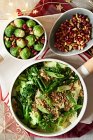 Brussels sprouts, savoy cabbage and broccoli with pomegranate seeds, and nuts for Christmas — Stock Photo