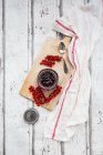 Marmellata fatta in casa con ciliegia e ribes rosso su fondo di legno bianco. — Foto stock
