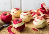 Maçãs vermelhas com maçã na tábua de corte. — Fotografia de Stock