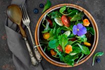Весняний салат помідори, огірки та їстівні квіти — стокове фото