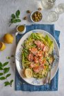 Salade d'orzo et saumon fumé chaud avec haricots, laitue et vinaigrette citron et huile d'olive — Photo de stock