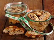 Cantuccini with cranberries in glass jars with ribbon — Stock Photo