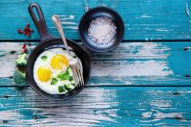 Healthy breakfast with fried eggs and green organic broccoli in old cast iron pan — Stock Photo