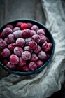 Bowl of frozen cherries in bowl with cloth on background — Stock Photo
