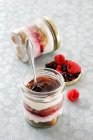 Tiramisu with forest berries in glass jars and on metal cover at table — Stock Photo