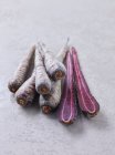 Ganze und halbierte lila Karotten — Stockfoto