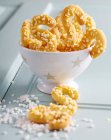 Biscuits au beurre en forme de S avec sucre à la plume dans un petit bol — Photo de stock
