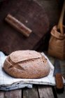 Homemade bread loaf on tea towel — Stock Photo