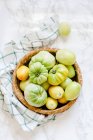 Tomates verdes en una cesta - foto de stock