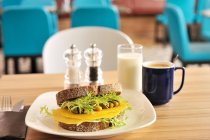 Vieux sandwich au fromage hollandais avec des serviettes et du café à salade et un verre de lait — Photo de stock