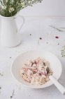 Overnight oats or bircher muesli with coconut and cranberries, and fresh daisies — Stock Photo