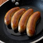 Salsichas inglesas (salsichas de pequeno-almoço) em frigideira — Fotografia de Stock