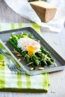 Roasted asparagus with poached egg, pine nuts and wine cheese — Stock Photo