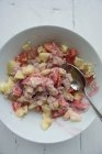 Muesli con harina de avena, melones, manzanas y yogur en tazón con cuchara - foto de stock